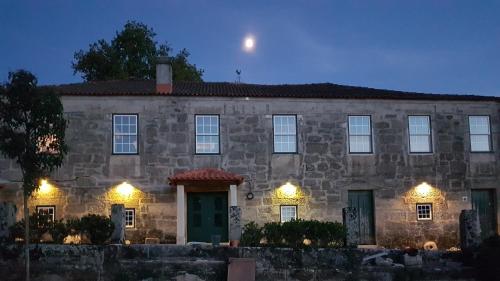 a stone house with lights in front of it at Solar dos Pedrosos in Vila Chã