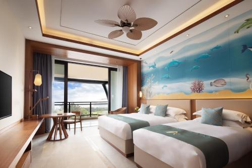 a hotel room with two beds and a fish mural at Arcadia Resort Hainan in Lingshui