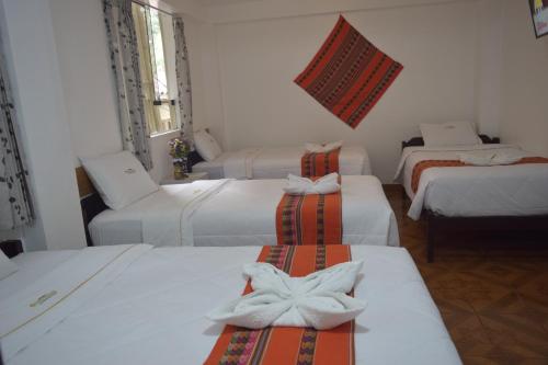 Zimmer mit 4 Betten in einem Zimmer in der Unterkunft HOTEL VALLE DORADO MACHUPICCHU in Machu Picchu