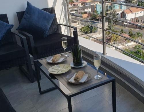 薩利納斯的住宿－Jade Aparts Salinas，一张桌子,上面放着一瓶和两杯葡萄酒