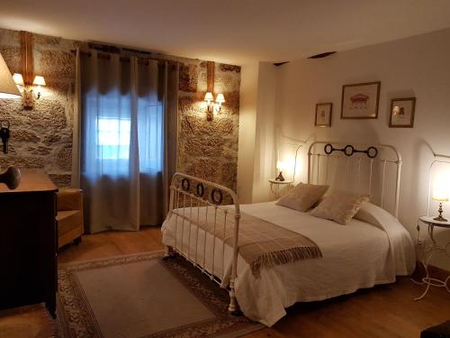 um quarto com uma cama branca e uma janela em Solar dos Pedrosos em Vila Chã