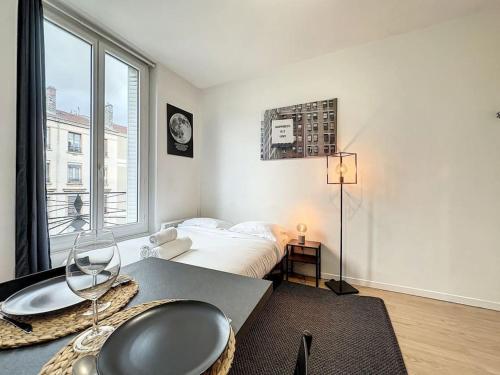 um quarto com uma cama e uma grande janela em Cosy studio, Cours Émile Zola 2 em Villeurbanne