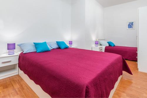 a bedroom with a large bed with a red blanket at Apartments by the sea Fazana - 6957 in Marana