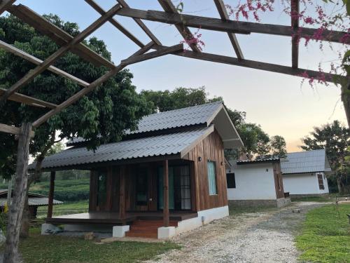 a small house with a metal roof at Punpawn ปั๋นปอนด์ Farm Stay in Chiang Saen