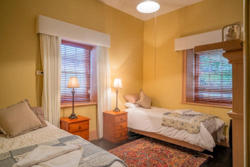 a bedroom with two beds and a window at Hartley Historic Cottages in Hartley