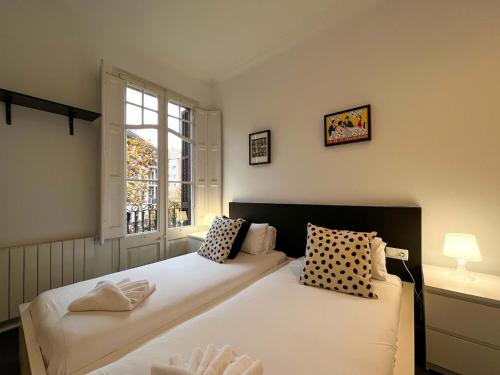 two beds in a room with a window at Stay Unique Apartments Cent in Barcelona