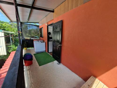 ein orangefarbenes Gebäude mit einer Tür und einem grünen Teppich in der Unterkunft Casa luna in Puerto Viejo