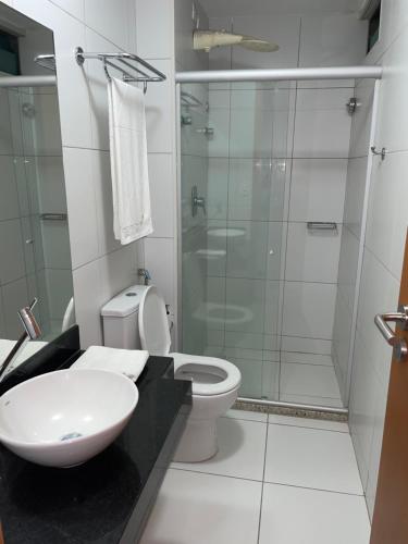uma casa de banho com um chuveiro, um WC e um lavatório. em Apartamento Iloa residence na Barra de São Miguel