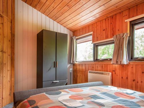 a bedroom with a bed and a cabinet and windows at Dornie Lodge in Beauly