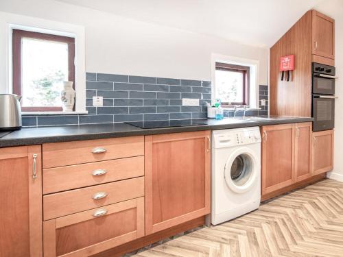 a kitchen with a washer and dryer in it at Auld House in Brora