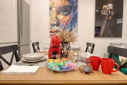 a dining room table with a wooden table with red cups at Apartamento Lokys centro ciudad, parking privado gratuito in Murcia