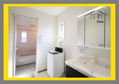 een witte badkamer met een wastafel en een spiegel bij ヴィラ ザ・キューブVilla The Cube Fuji view Annovillas in Fujikawaguchiko