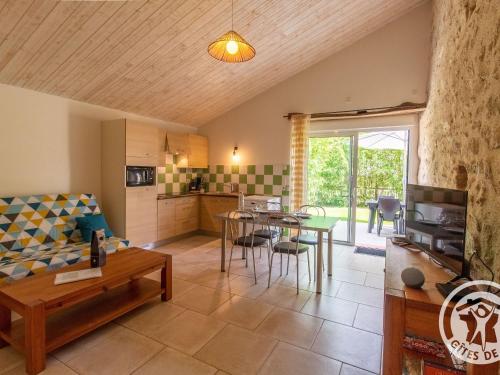 un salon avec un canapé et une table dans l'établissement Gîte cosy entre Cholet et Puy du Fou, terrasse, accueil PMR, proche sites touristiques, parking inclus - FR-1-622-32, à Saint-Christophe-du-Bois