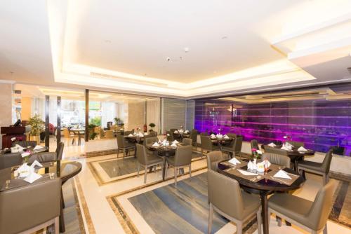 um restaurante com mesas e cadeiras e iluminação roxa em فندق ستي فيو- City View Hotel em Jeddah