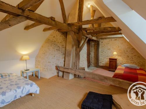1 dormitorio en un ático con vigas de madera en Gîte Huillé-Lézigné, 3 pièces, 4 personnes - FR-1-622-45 