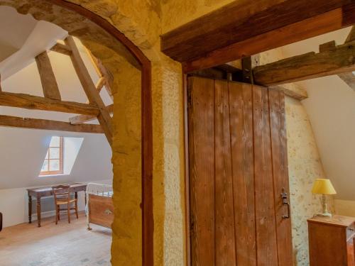 a barn door in a room with a dining room at Maison 15ème siècle à Huillé, 2 ch, jardin, cheminée, proche Loir et pistes cyclables - FR-1-622-45 in Huillé