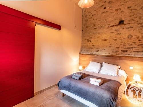 - une chambre dotée d'un lit avec un mur rouge dans l'établissement Gîte Saint-Christophe-du-Bois, 2 pièces, 4 personnes - FR-1-622-33, 