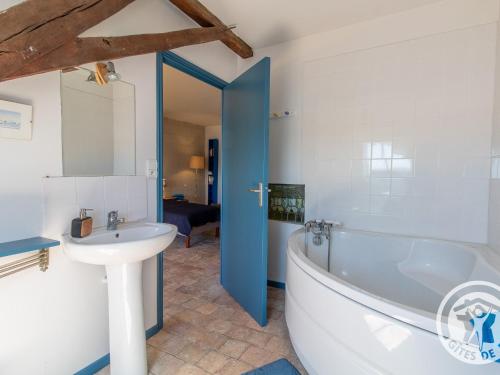 een badkamer met een bad en een wastafel bij Gîte Ingrandes-Le Fresne sur Loire, 5 pièces, 8 personnes - FR-1-622-38 in Ingrandes