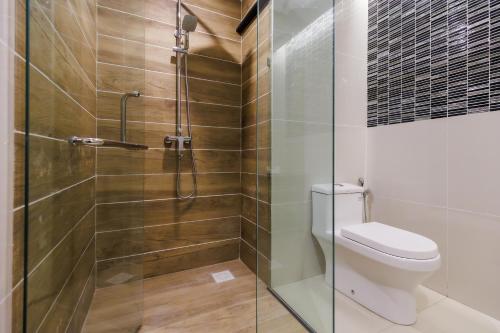 a bathroom with a toilet and a glass shower at 56 Hotel in Kuching
