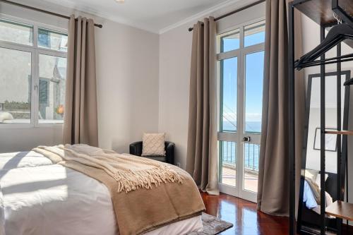 a bedroom with a bed and a large window at Freitas Paradise, a Home in Madeira in Ponta do Sol