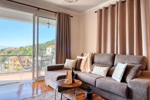 a living room with a couch and a large window at Freitas Paradise, a Home in Madeira in Ponta do Sol