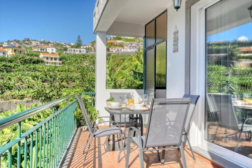 a patio with a table and chairs on a balcony at Freitas Paradise, a Home in Madeira in Ponta do Sol