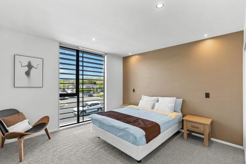 a bedroom with a bed and a large window at CBD Contemporary Comfort Townhouse 2 Bed 2Bath in Christchurch