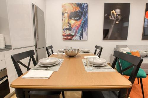 a dining room table with chairs and a painting on the wall at Apartamento Lokys centro ciudad, parking privado gratuito in Murcia