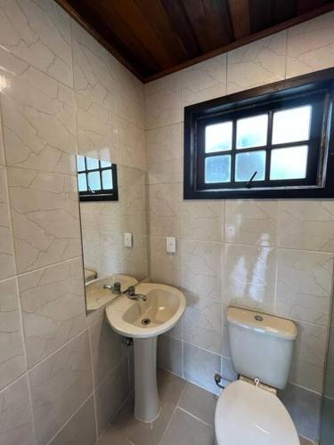 a bathroom with a toilet and a sink and a mirror at Beautiful view room in Angra dos Reis