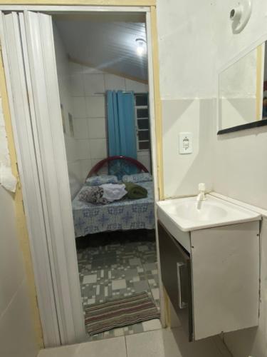 a small bathroom with a sink and a mirror at Pousada Matriz in São Thomé das Letras