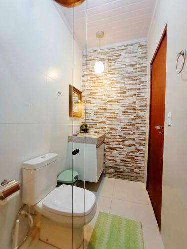 a bathroom with a toilet and a brick wall at LEGATUM POUSADA - Próx a BR 101 e Partage Shopping in Campos dos Goytacazes