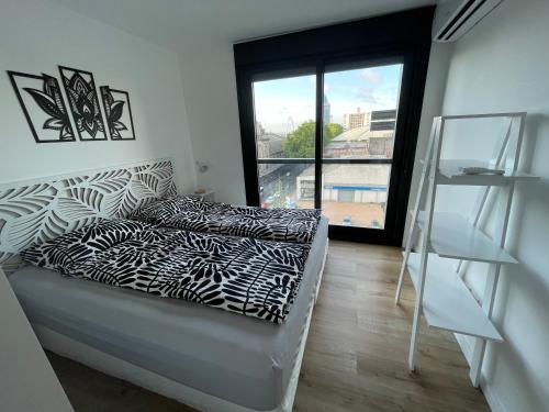 1 dormitorio con cama y ventana grande en UruSamKa Apartamento 2 dormitorios en Centro MoNteVidEo, en Montevideo