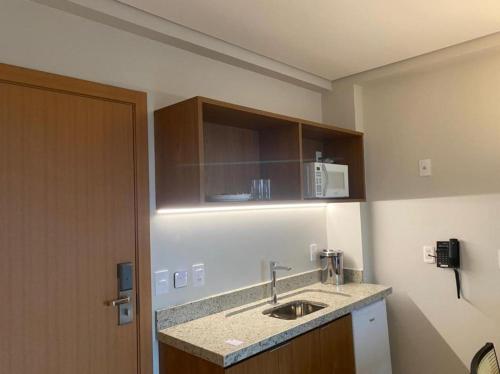 uma cozinha com um lavatório e um micro-ondas na parede em Apartamento em Salinas Exclusive Resort em Salinópolis