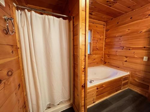 e bagno con tenda da doccia bianca e vasca. di Smokey Mountain Retreat, hot tub, game room, sleeps 8! a Gatlinburg
