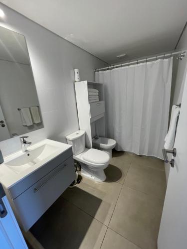 een witte badkamer met een toilet en een wastafel bij UruSamKa Apartamento 2 dormitorios en Centro MoNteVidEo in Montevideo