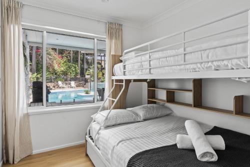 a bedroom with a bunk bed and a pool at Exquisite Beachside Luxury- Resort Style Pool in Wamberal North