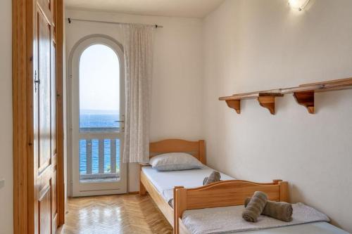 1 dormitorio con 2 camas y ventana grande en Seaside family friendly house with a swimming pool Prigradica, Korcula - 21022, en Blato