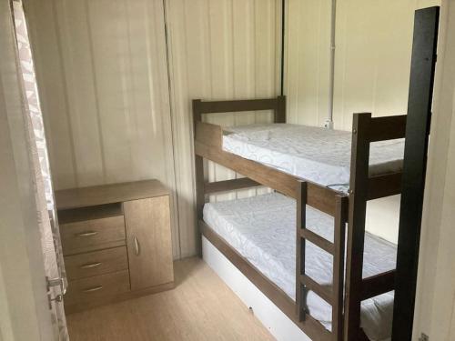 a small room with two bunk beds and a chair at Casinha na serra para até 4 pessoas in Nova Petrópolis