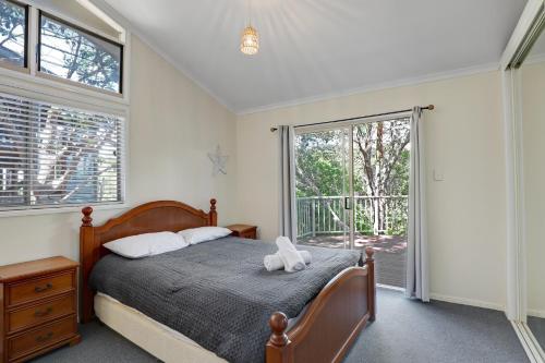 a bedroom with a bed and a large window at Amaroo House in Point Lookout