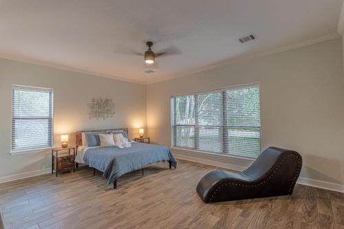 um quarto com uma cama e uma cadeira em Lake Conroe Sunset House em Willis