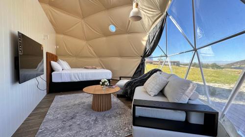 a room with a bed and a couch in a tent at Glamping Dome - Rosé in Cromwell