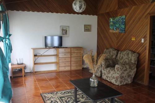 a living room with a chair and a table at Casa Luka in Turrialba