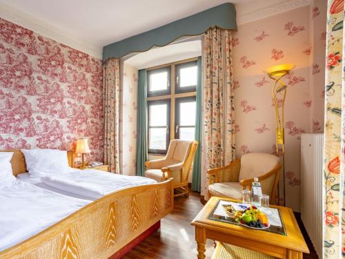 Hotel Burg Staufenberg في Staufenberg: غرفة نوم بسرير وطاولة عليها صحن من الفواكه