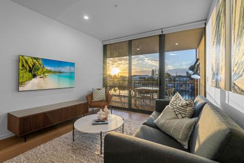 a living room with a couch and a table at The Riverview - Brand New Modern 2BR with King Bed, Parking & Pool in Gold Coast