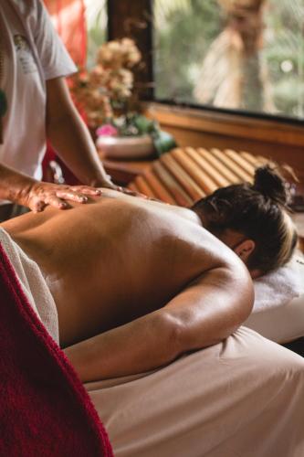 a woman laying on a bed getting a massage at Ilha de Toque Toque Eco Hotel in São Sebastião