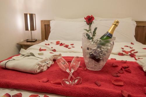 a bed with a bottle of champagne and a vase of roses at Ilha de Toque Toque Eco Hotel in São Sebastião