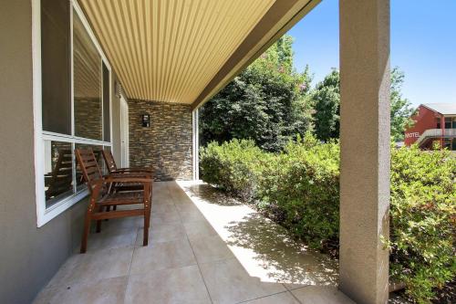 a porch with two chairs on a house at 4 Anderson - In the heart of Bright! in Bright