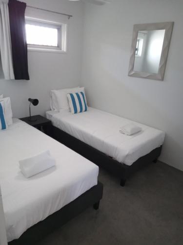2 camas en una habitación con espejo en Maroochy Sands Holiday Apartments, en Maroochydore