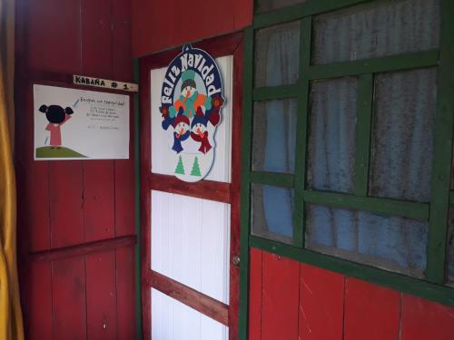 una puerta de granero roja con un letrero. en Hostal tachiwa, en Puerto Nariño