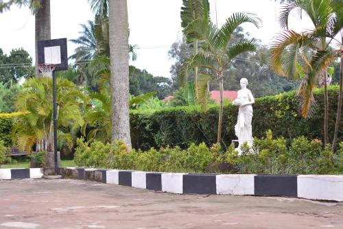 a statue of a man standing in a park at St. Patrick’s Forest House in Entebbe